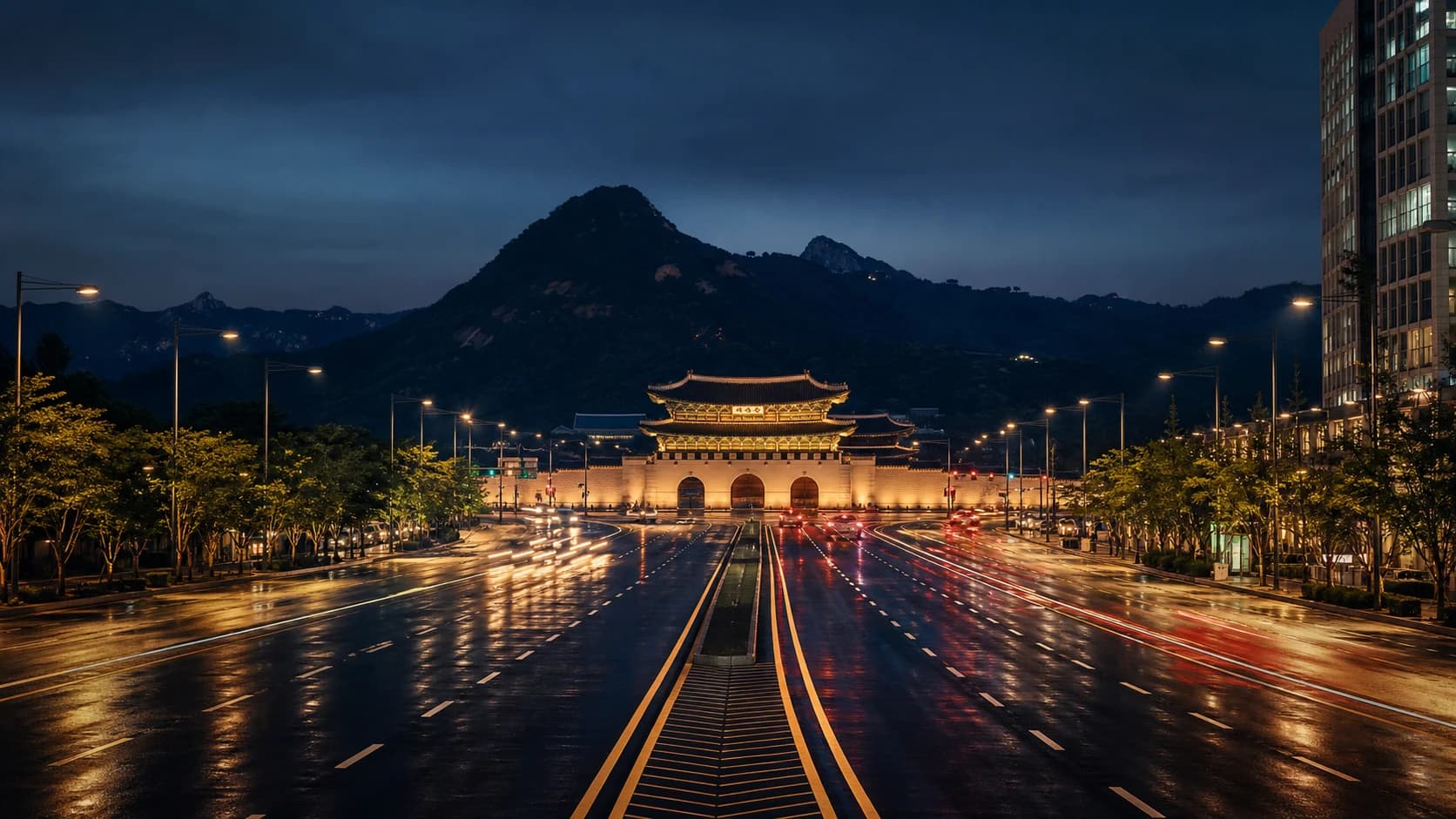 A centered nighttime view down Sejong-daero toward Gwanghwamun Gate in Seoul